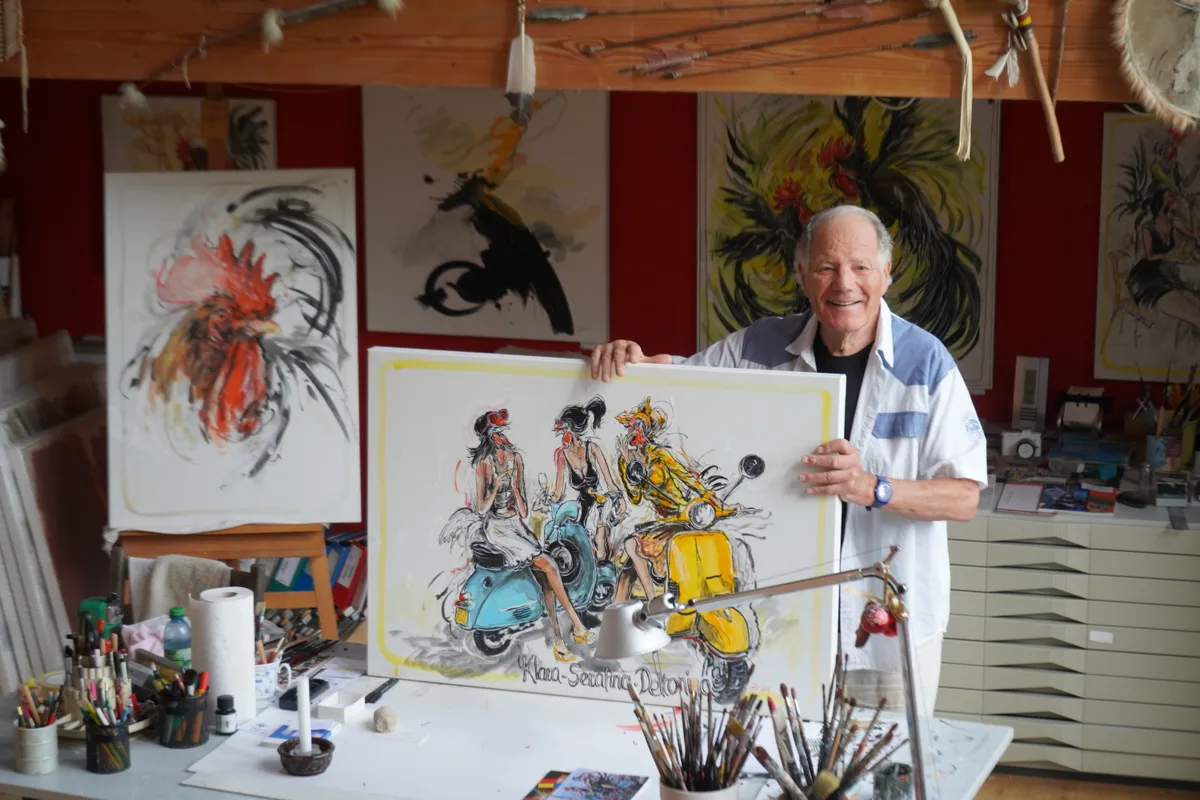 Man sieht Bühler, wie er eines seiner Bilder hält.